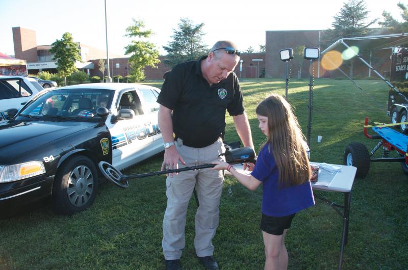 Rochester Police Chief Paul Magee shows Kathleen Dunn how to use one of the department's metal detectors. BY GEORGIA SPARLING
