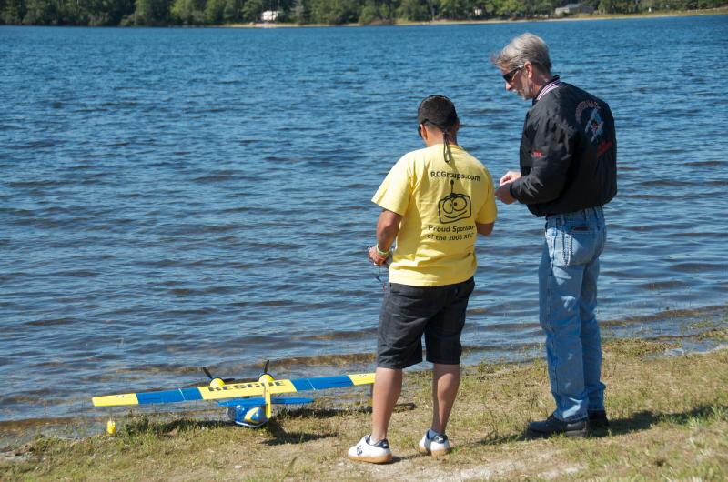 Jesse Rodriguez, left, and Paul Bartolo confer before sending a replica of a WWII rescue plane into the air. BY GEORGIA SPARLING