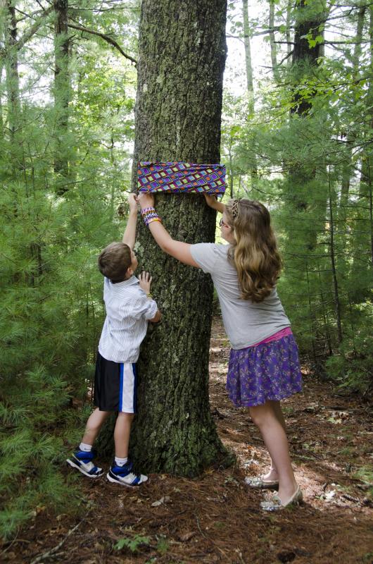 Quintin Zell and Makena Wolfe, grandchildren of Herb Wood, unveiled the new sign at the opening of the trail. BY GEORGIA SPARLING