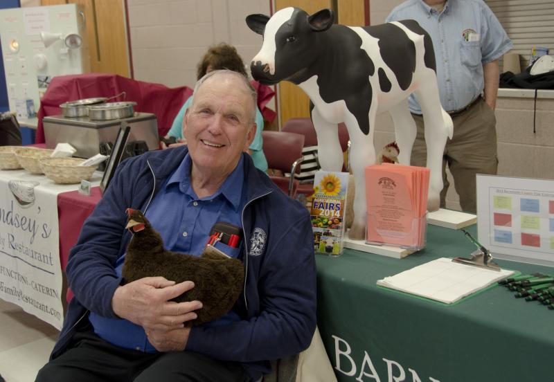 Barnstable County Fair Director Peter Lindberg brought a cow and chicken to his booth. "You can call her Melvina, if you want," Lindberg said of the chicken. BY GEORGIA SPARLING