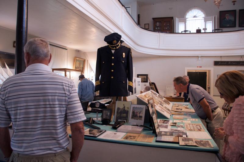 A view of the Police Department side of the exhibit, including Chief James Moran standing in front of his uniform. "It still fits," said Moran. BY GEORGIA SPARLING