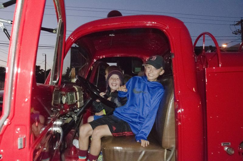 Thomas Janicki and Torsten Brickley play in the Fire Department's antique truck. BY GEORGIA SPARLING