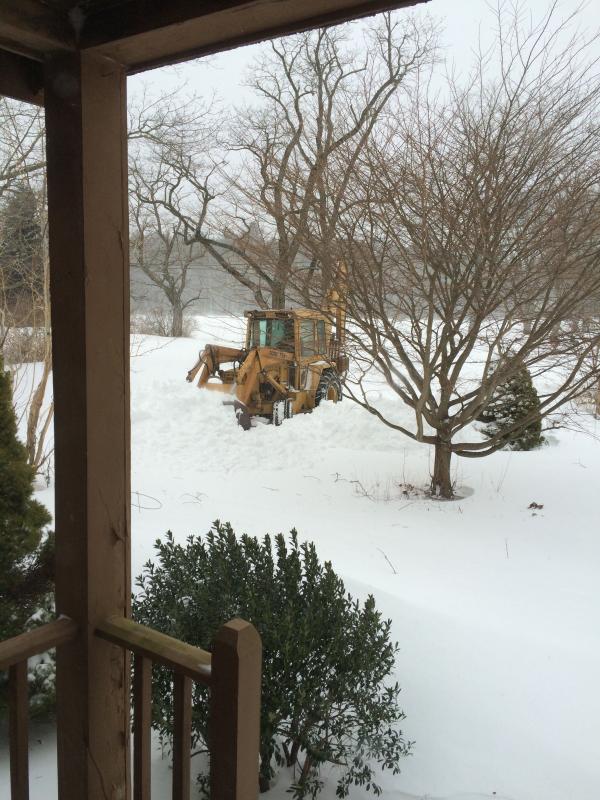 Ned Johnson plows his driveway with a backhoe in Rochester. COURTESY EDYIE JOHNSON