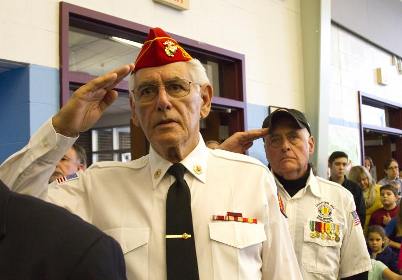 Veterans Charlie Soares and Ray Hanks, who both served in the Marines, salute the flag. BY GEORGIA SPARLING