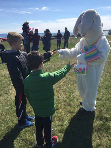 8-year-old Jack Higgins of Mattapoisett (left) with little his brother, 6-year-old Charlie Higgins, are handed candy by the Easter bunny. BY SARA LAFRANCE