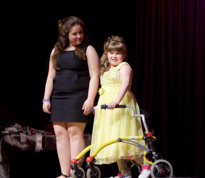 Molly Menard recently began walking. Here she stands with ORR student Sarah Achorn, one of many volunteer assistants. BY GEORGIA SPARLING