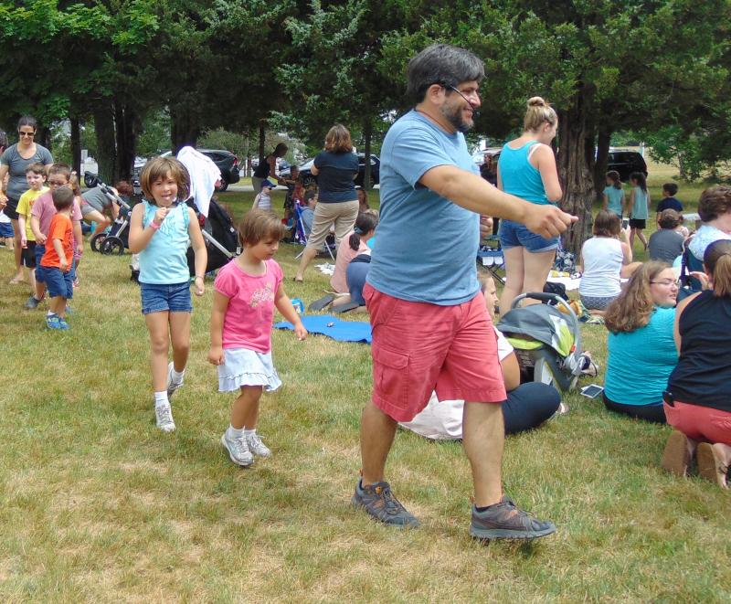 Lovegrove leads a train of children as Poitras plays a rendition of "Little Red Caboose." BY TANNER HARDING