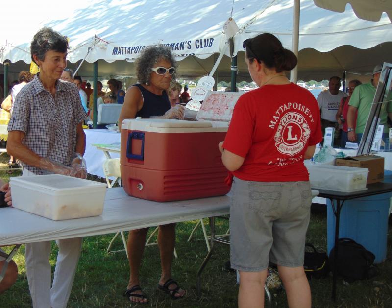 Connie Hayes, the Lions' "strawberry shortcake chairperson," and Gail Lockwood, a volunteer, serve up strawberry shortcake at Shipyard Park. BY TANNER HARDING