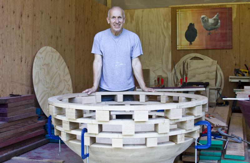 Wood sculptor John Magnan stands with a piece from his upcoming series, 'The Hero's Journey.' BY GEORGIA SPARLING