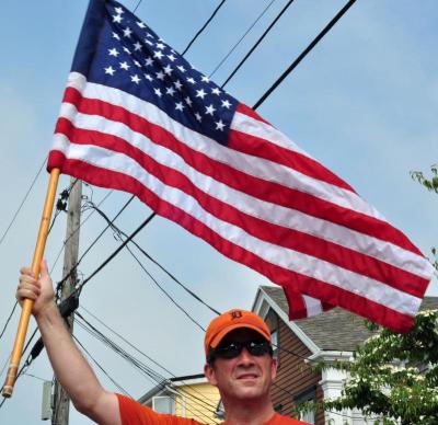 "It's a tribute to the country," said Bill Foley, of Mattapoisett, about running the race while brandishing his large American flag. Foley has run the past several years with the flag. BY MATT CAMARA