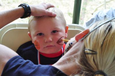 Cooper Cambridge, 2, of Mattapoisett, appears thrilled to have his face painted in Shipyard Park on Saturday. BY MATT CAMARA