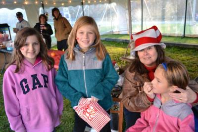 Carol Adler, of Mattapoisett, paints Bulldog pride on the face of nine-year-old Grace Greancy while her friends Brianna Lynch, left, and Hunter Moreau, center, look on. BY JENNIFER HESHION