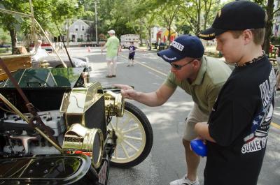 Barry McGrath, left, explains the mechanics of a Ford Model 666 to his son Carson. BY GEORGIA SPARLING
