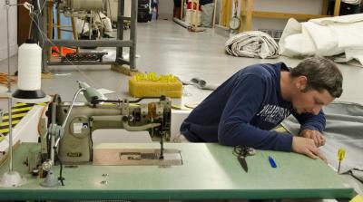 Employee Ryan Kelso repairs a canvas cover using one of the shop's recessed sewing machines. BY GEORGIA SPARLING