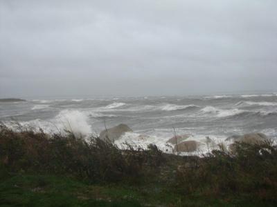 Waves break on the rocks at the edge of the Kittansett Club's parking lot late Monday afternoon. By nightfall, the water had flooded the streets. BY PATRICK LESTER