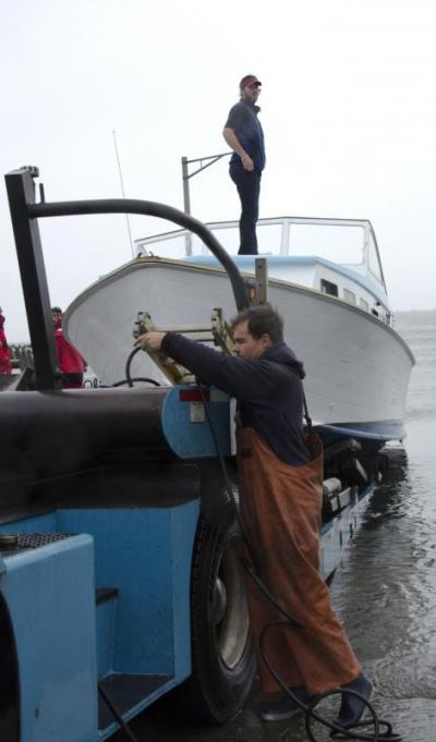 Alan Johnson of Brownell Systems helped pull out a last boat from Mattapoisett Harbor on Monday morning. Although a few boats were still moored, Johnson said they were done for the duration of the storm. BY GEORGIA SPARLING