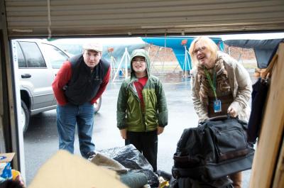 Despite the nor'easter, Huggins had a steady stream of local residents dropping by her storage unit to drop off relief supplies. Tad, left, Nathaniel, and Bridgit Wollenhaupt came by on Thursday afternoon with several bags to donate. BY GEORGIA SPARLING