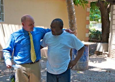 Scott Egan, CIP's youth minister, and EBO's pastor Joseph Belizaire chat under the palm trees. BY GEORGIA SPARLING