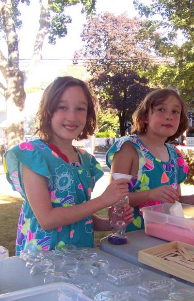 Identical twins Bridget (left) and Audrey Wallace enjoy the sand art station. The sisters look so much alike their father double-checked before identifying them for Sippican Week. BY MATTHEW BERNAT
