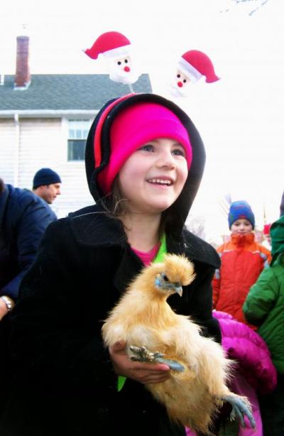 Rochester's Madelyne Denham hugs a baby chicken during the Marion Village Stroll. A pint-sized petting zoo was set up off Front Street for the event. BY MATTHEW BERNAT