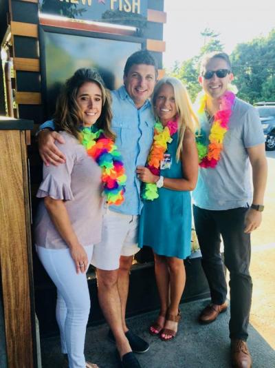 Jill Fearons, second from right, and FUN 107 radio personality and DJ Michael Rock, right, take a moment to pose in front of Brew Fish Bar & Eatery with Maurine and Todd Rodrigues, owners of Yard Boss and Windswept in Mattapoisett. BY CHRIS REAGLE