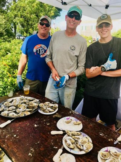 On hand from Copper Beach Farm to shuck oysters were, from the left, Tad Morse, owner Bob Field, and oyster farm hand Freemin Baur, 18. BY CHRIS REAGLE