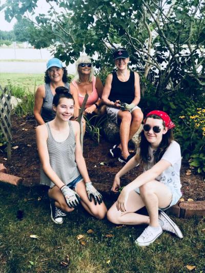 Old Rochester High School seniors Abigail Lacock, 17, left, and Madeleine Root,17, joined teachers, Karen Browning, second row left, and Lynn Connor, and Mattapoisett Women's Club member Elaine Botelho Aug. 15, to spruce up the school's memorial gardens. BY CHRIS REAGLE