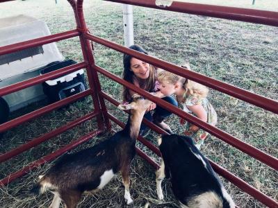 Kristen Desrosiers, introduces her daughter, Alyvia Elmes, 3, to some goats at the Rochester Country Fair livestock exhibit. BY CHRIS REAGLE