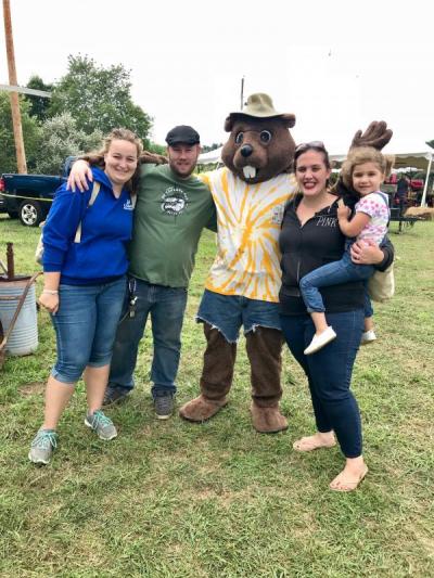 "Buck Chuck", the Rochester Country Fair mascot, roamed the fairgrounds delighting children and stopping for photo opportunities, including this one featuring, from left, Stephanie Maurer, of Carver, Michael Carberry, of Rochester, and Kelsey Davis, of Fall River, holding her daughter, Vivienne Fitzgerald, 3. BY CHRIS REAGLE