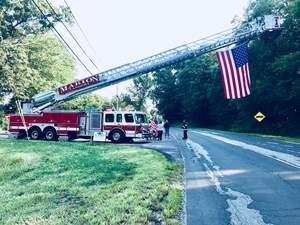 Marion Fire Dept. lent their fire ladder truck to display a large American flag along the cyclists' procession route to the Rochester Firefighters Memorial on Hartley Road in support of The Brotherhood Ride.