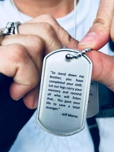 Tracy Eldridge, of Rochester Fire Dept., displays the dog tags she wears bearing an inscription of a verse written by Brotherhood Ride founder Jeff Morse.