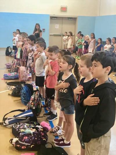 Center School students sing the National Anthem on their first day back at school on Tuesday, Aug. 28.