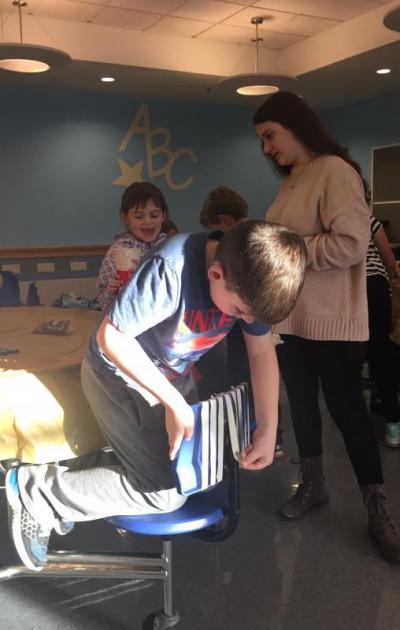 Dominic Philie lines up the tape on the back of his chair before using it. Photo by: Grace Ballenger