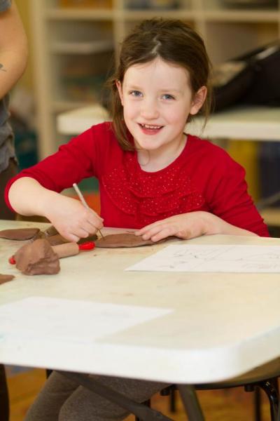 Eliza Grady of Mattapoisett looks up for a moment while working on an Adventure box. Photo by: Andrew Griffith