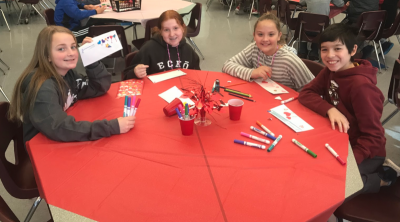 Students make Valentine’s Day cards to accompany a donation of books they sent to students in Uganda.