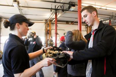 Mattapoisett Firefighter Rebecca Smith hands a breathing apparatus mask to Kevin Cahill, one of nine attendees at the "Come and Experience Being a Firefighter" event. Photo by: Katherine Glosser