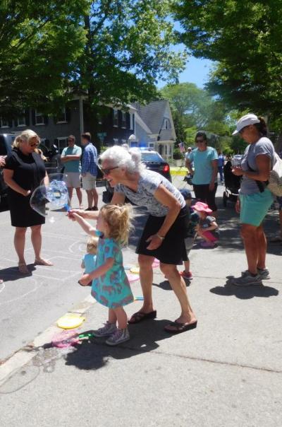Kelli McSweeney takes advantage of the children’s activities at the event to blow bubbles with Vivienne Sanford. Photo by: Grace Ballenger