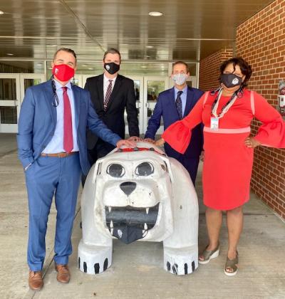 Craig Davidson, the district’s new director of student services (left), Superintendent Michael Nelson (center left), the district’s new Assistant Superintendent of Finance and Operations Howie Barber (center right) and Janell Pearson-Campbell, the new assistant superintendent of teaching and learning (right) pose outside of ORHS with the famed bulldog. Photo courtesy: Old Rochester Regional School District