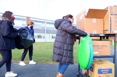 A load of toys are hauled by Andrea Moniz (right), Cameran Weaver (center) and Grace Ticewick (left) from the cruiser to the Old Rochester building. Photo by: Aidan Pollard