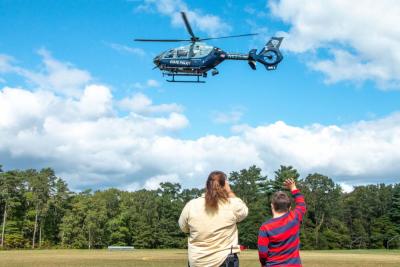Kate Souza (left) and Seventh Grader Thomas Jupin (right) wave to a Mass. State Police Airwing helicopter as it leaves ORR High School after a first responders career presentation on Sept. 30. Photo by: Morgan Beard.