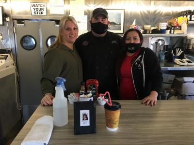 Mattapoisett Diner owner Brian Vose, center, with waitresses Lynnsey Johnson, left, and Sheri Bird at the memorial at the bar stool where Elaine Vandament regularly sat. Photo by: Sandy Quadros Bowles