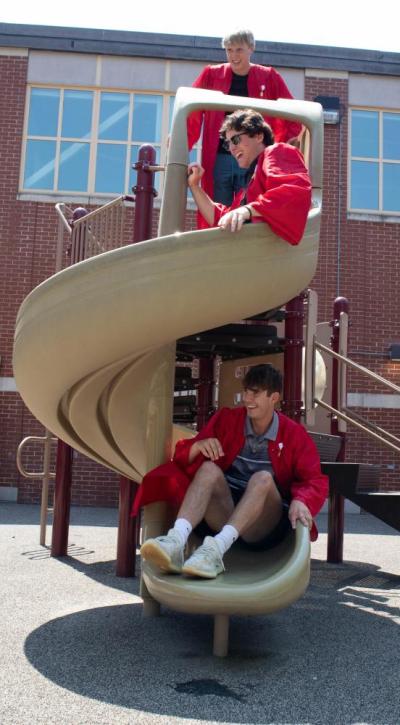 From top to bottom: Ryan Blanchett, Brady Lee and Gage Beauchemin declare themselves “kings of the playground” and take a trip down the Center School slide.