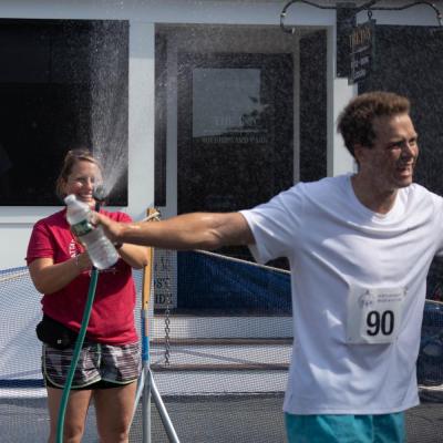Ten-year road race volunteer Ashley Sweatland helps Acushnet resident Sean Brown cool down after the race.