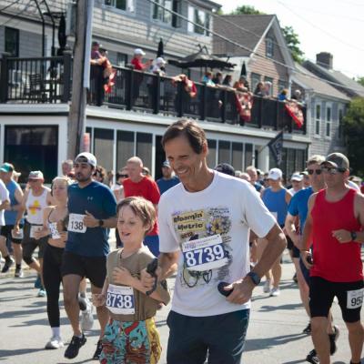John Schluter, right, and nine-year-old B. Schluter run down Water Street in Mattapoisett. Photo by Sawyer Smook-Pollitt