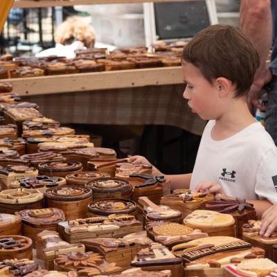 Mattapoisett resident Adam Barber, 6, looks at a selection of wood crafts. Photo by Sawyer Smook-Pollitt