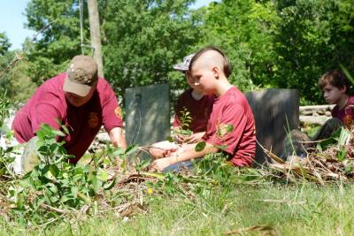 Kevin Gretton, Zachary Bellefeuille, Timothy Lassiter and Logan Bradshaw look at a grave marker at Hammond Cemetery on Friday, July 19. Photo by Erez Ben-Akiva