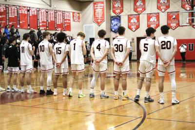 Old Rochester boys basketball starters anticipate an intense game as they stand for the national anthem.