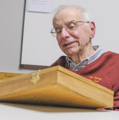 John Oliveira inspects the original divining rods used by Middleboro dowser Charles Harris, who used the rods to find water in 1973. Olivera said he hadn’t seen the rods since that time.
