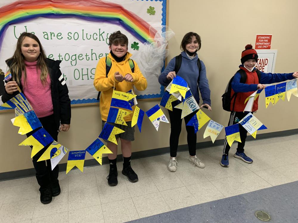 Fifth grade students Fiona Payne, Wyatt Churchill, Jacqueline Cobler and William Lucy hold the banner they helped to create.