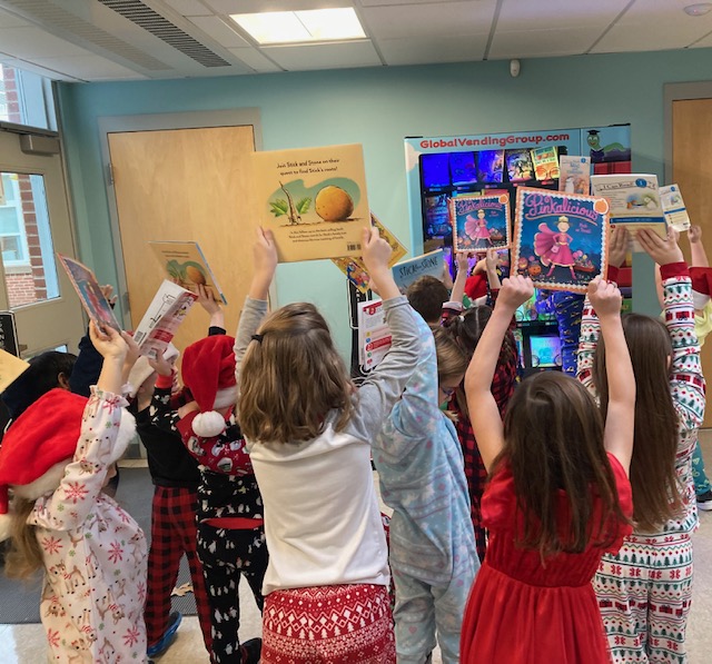 Mrs. Lenahan's first grade class holds up their book selections.
